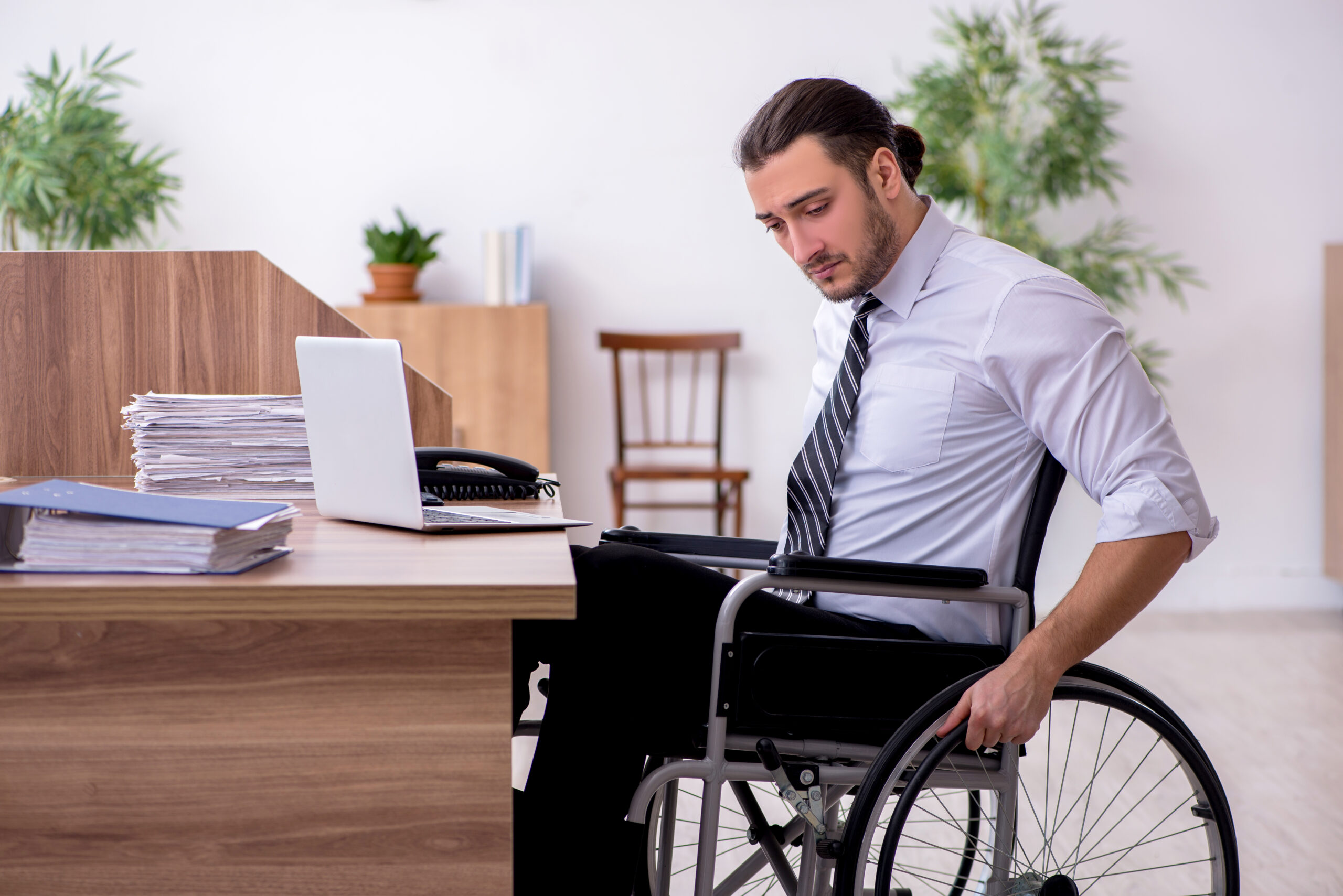 Young disabled employee suffering at the workplace